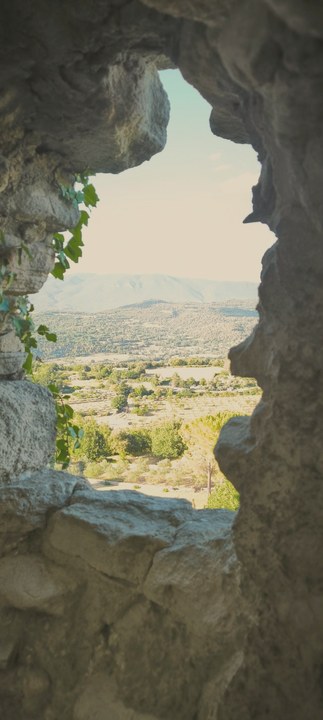 Vue sur une vallée française à travers une ouverture dans la roche