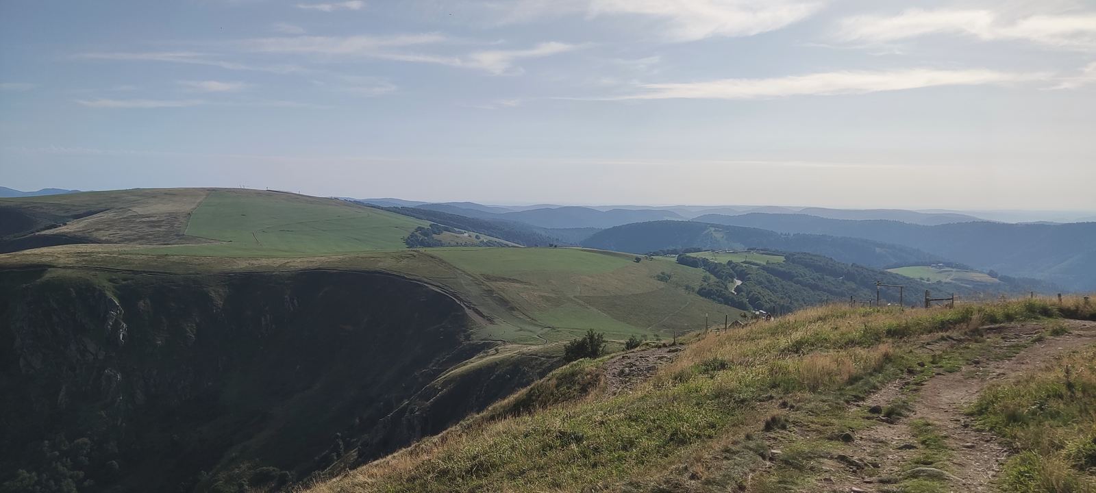 Chemin sur un plateau français dominant des reliefs successifs dans une lumière douce