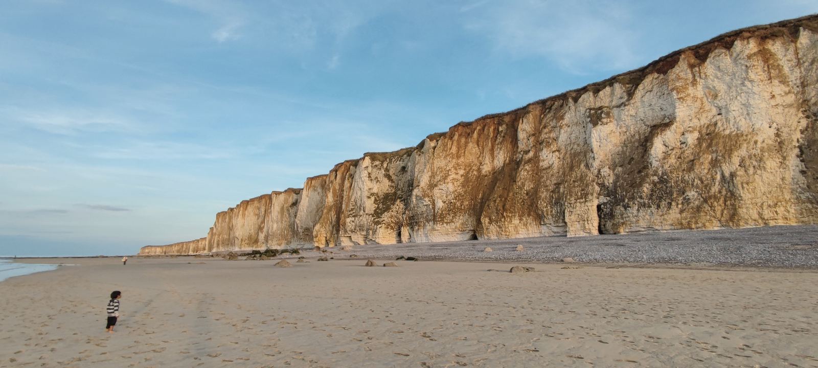 Falaises claires dominant une plage calme sur le littoral français