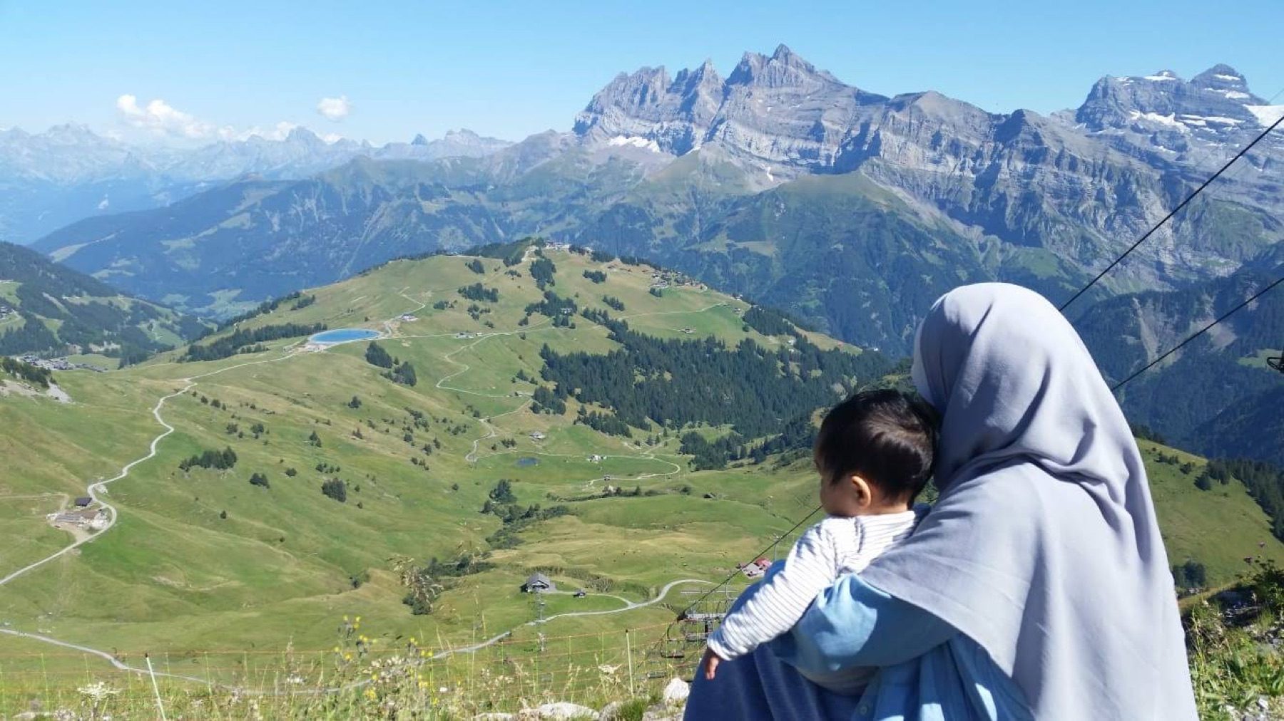 Mère et jeune enfant devant un vaste paysage alpin