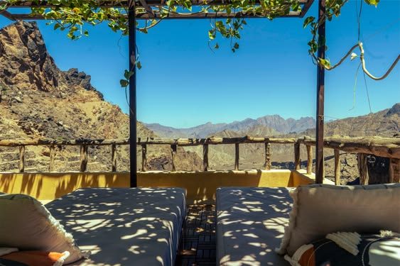 Terrasse ombragée déjà préparée face à un paysage de montagne