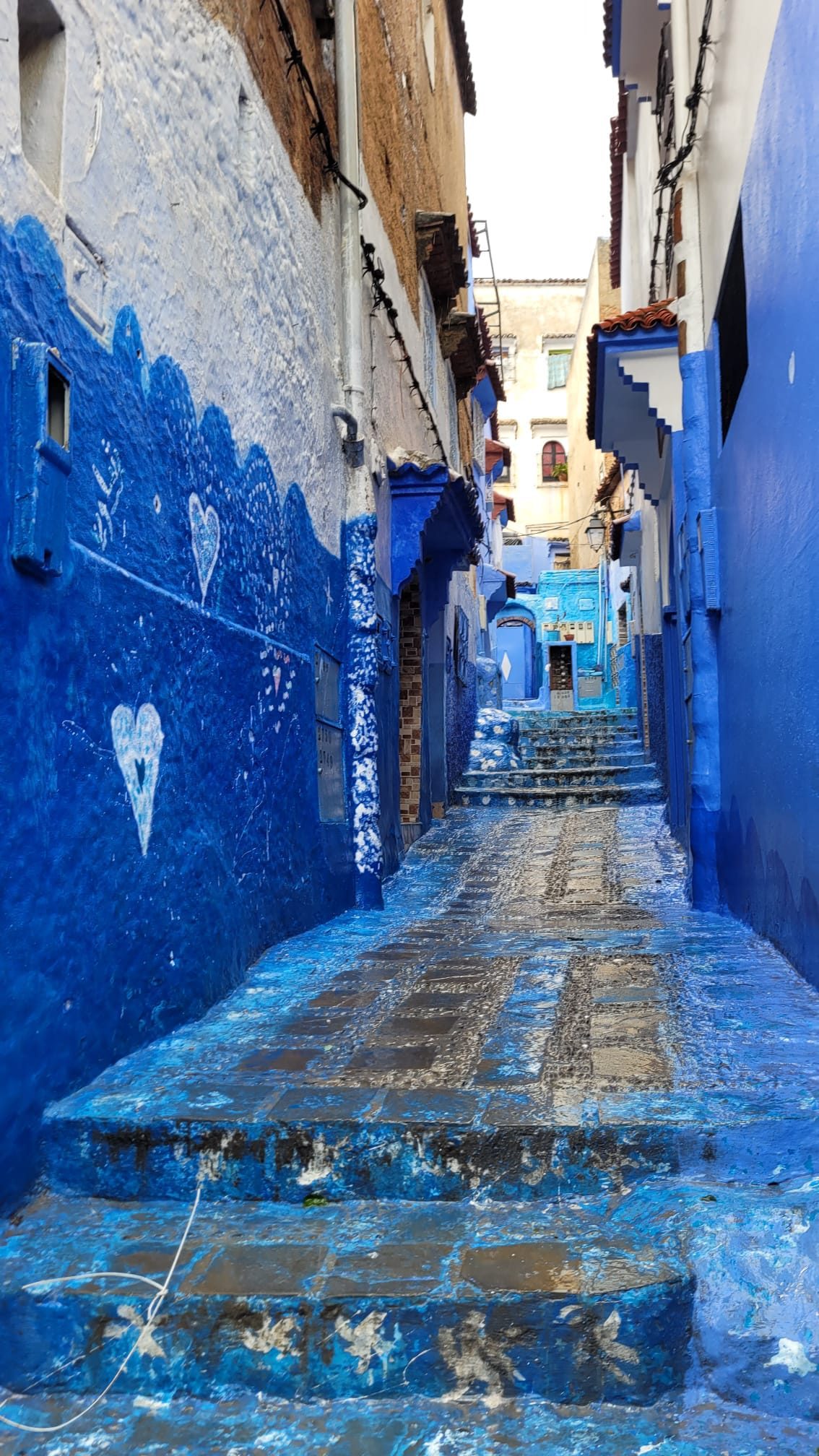 Ruelle bleue montant entre les maisons de Chefchaouen
