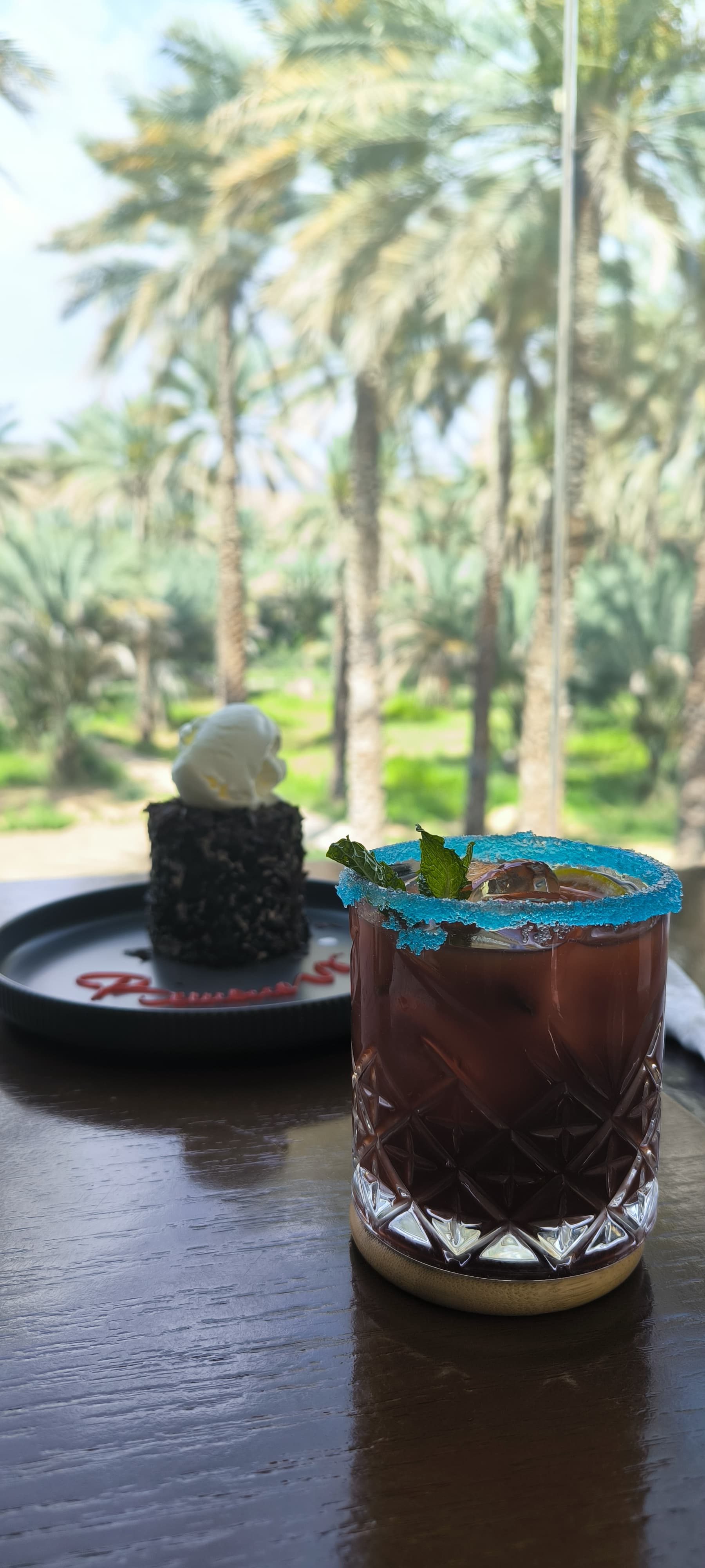 Dessert et boisson servis face à une palmeraie