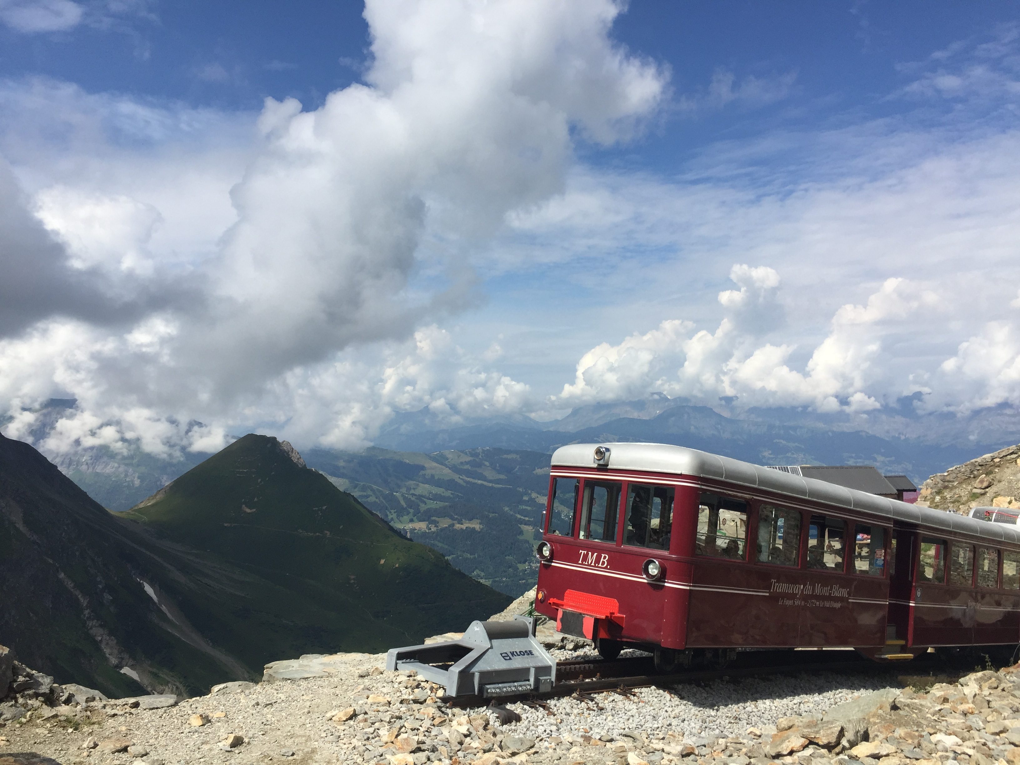 Train de montagne longeant une vallée sous un ciel ouvert