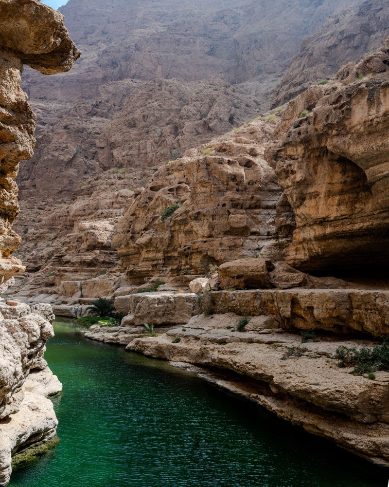 Wadi calme entre roche et eau dans les montagnes d’Oman